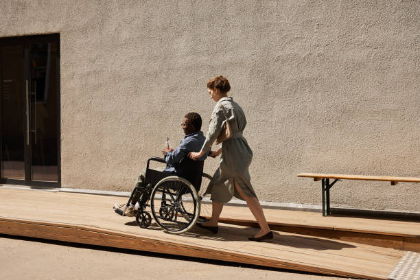 istock Nurse pushing wheelchair with disabled man 1331957291