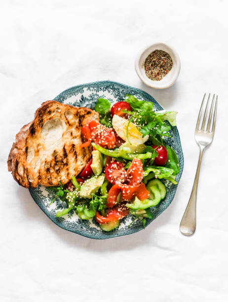 istock Delicious breakfast, snack - salad with salmon, egg, vegetables, lettuce and grilled bread on a light background, top view 1331960125