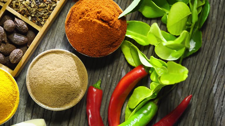 spices and condiments in bowls on wood background, top view.