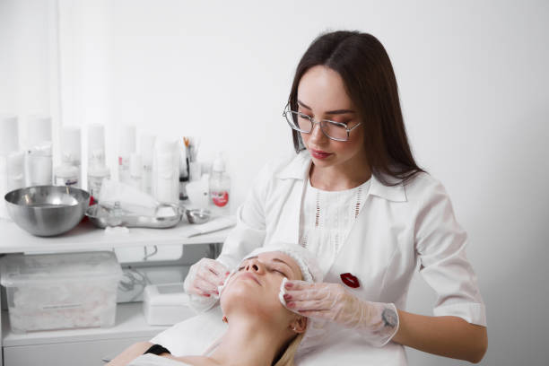 una esteticista profesional realiza un procedimiento mecánico de limpieza facial en el spa. hermosa mujer caucásica en un procedimiento cosmético. centro de salud - mud wellbeing spa treatment beautician fotografías e imágenes de stock