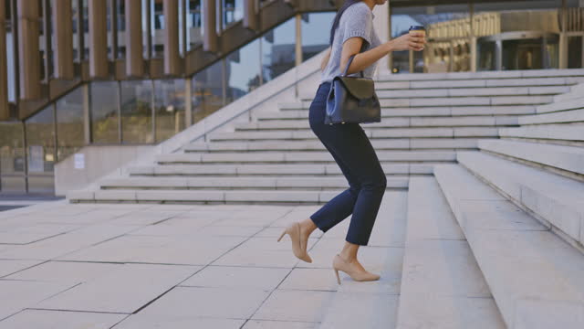 4k video footage of an unrecognizable businesswoman walking through the city alone