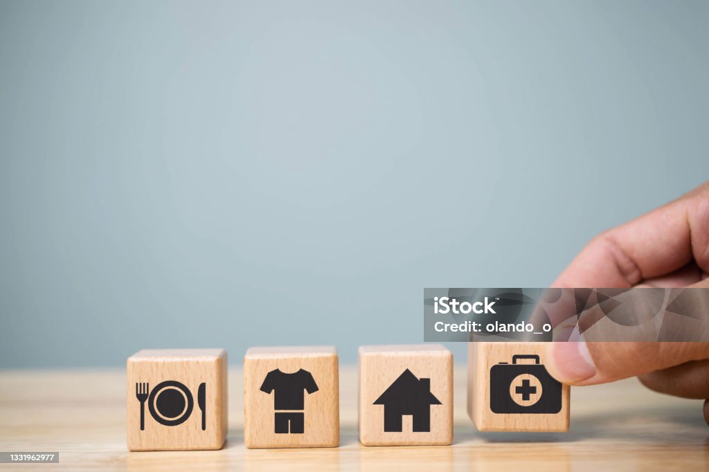 human hand placing cube with food Clothing, housing, medicine, four basic human needs concept. Dependency Stock Photo