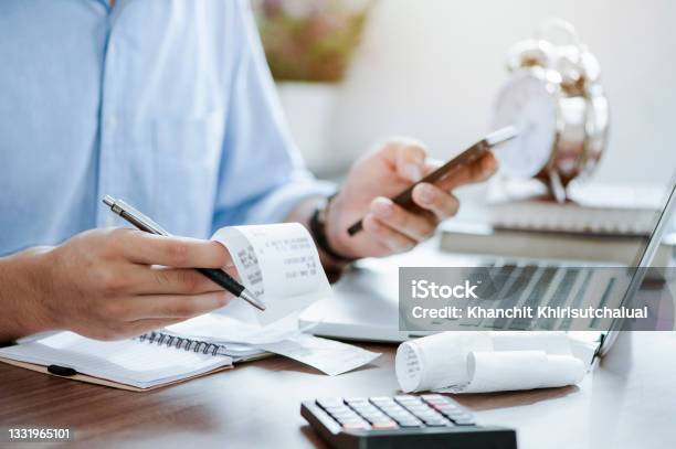 Young Man Holding Pen With Bills Working For Calculate Business Data Taxes Bills Payment Start Up Counting Finance Accounting Statistics And Analytic Research Concept Stock Photo - Download Image Now