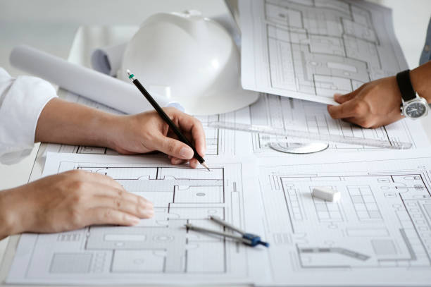 istock close up of team engineer or architect meeting for project working with partner and engineering tools on model building and blueprint in working site. Construction concept 1331965283