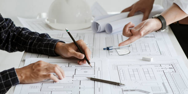 istock close up of team engineer or architect meeting for project working with partner and engineering tools on model building and blueprint in working site. Construction concept 1331965964