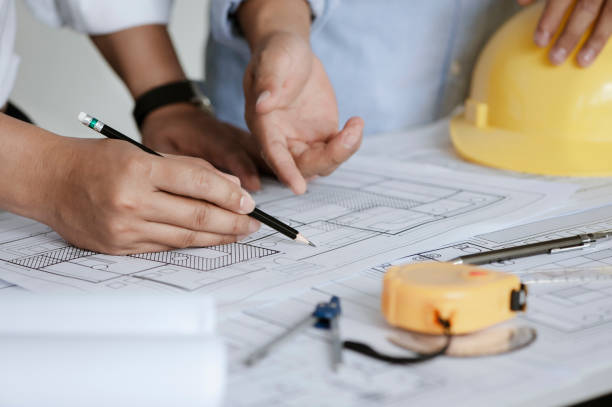 istock close up of team engineer or architect meeting for project working with partner and engineering tools on model building and blueprint in working site. Construction concept 1331966118