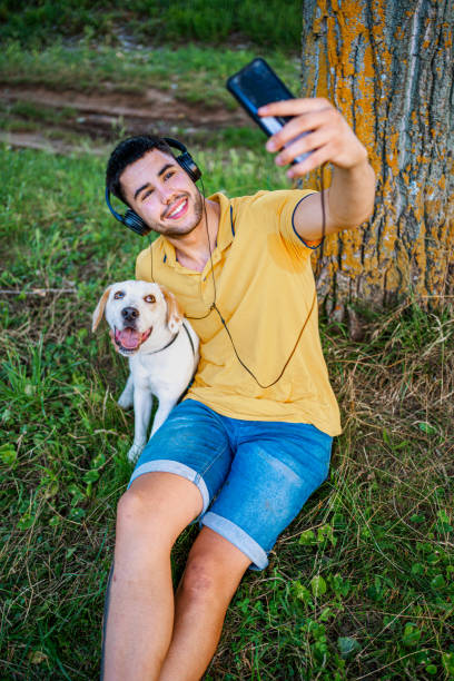 istock Young man taking selfie with dog in nature 1331966295