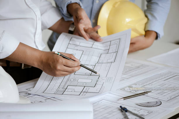 istock close up of team engineer or architect meeting for project working with partner and engineering tools on model building and blueprint in working site. Construction concept 1331966336