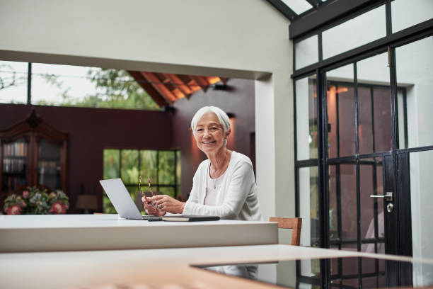 Shot of a senior woman using a laptop at home stock photo