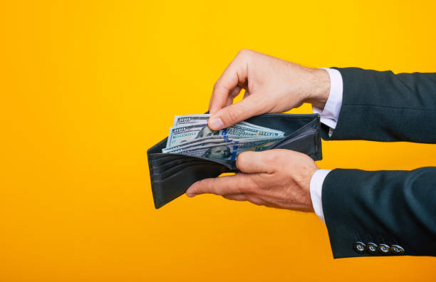 Close up photo of young successful businessman hands with wallet and bunch of dollars of USA Close up photo of young successful businessman hands with wallet and bunch of dollars of USA debt ceiling stock pictures, royalty-free photos & images