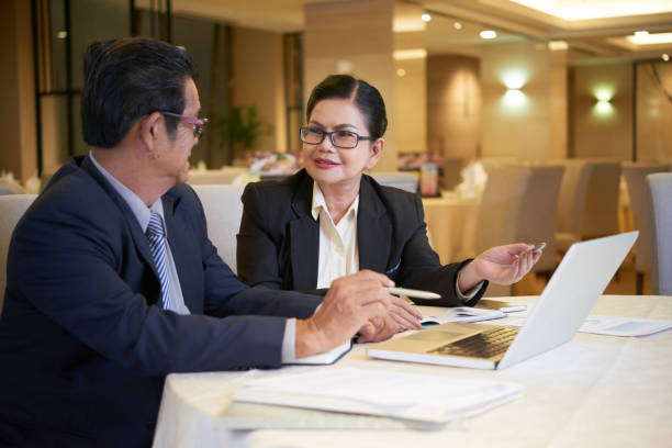 Colleagues Discussing Cooperative Project Positive senior business people having meeting at restaurant table, they are discussing cooperative project an dplanning work cfo stock pictures, royalty-free photos & images