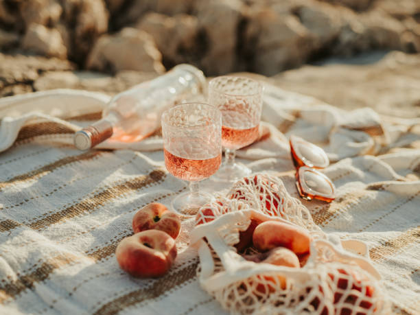 wino i brzoskwinie na pikniku morskim na świeżym powietrzu w zachodzie słońca – zdjęcie