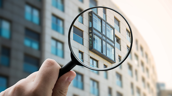 Magnifying glass focusing a modern apartment building facade