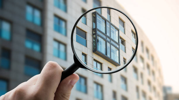 Magnifying glass focusing a modern apartment building facade stock photo