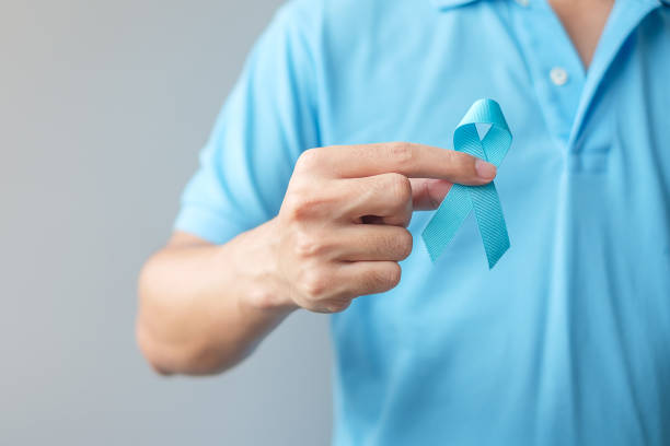November Prostate Cancer Awareness month, Man in blue shirt with hand holding Blue Ribbon for supporting people living and illness. Healthcare, International men, Father and World cancer day concept noviembre mes de concientización sobre el cáncer de próstata, hombre con camisa azul con la mano sosteniendo la cinta azul para apoyar a las personas que viven y la enfermedad. salud, hombres internacionales, padre y concepto del día mundial contra el