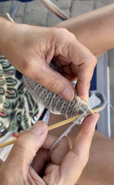 istock A woman knits a woolen scarf. Knitting needles. Work from home. Natural wool. 1331974092