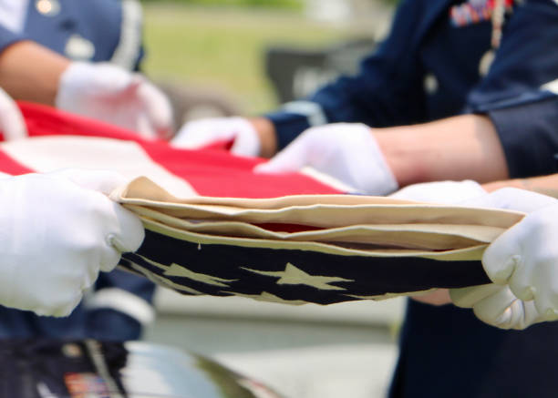 почетный гвардеец складывает американский флаг - military flag стоковые фото и изображения