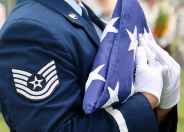 US Air Force Honor Guardsman carrying folded American flag US Air Force Honor Guardsman carrying tricorn folded American flag. mourner photos stock pictures, royalty-free photos & images