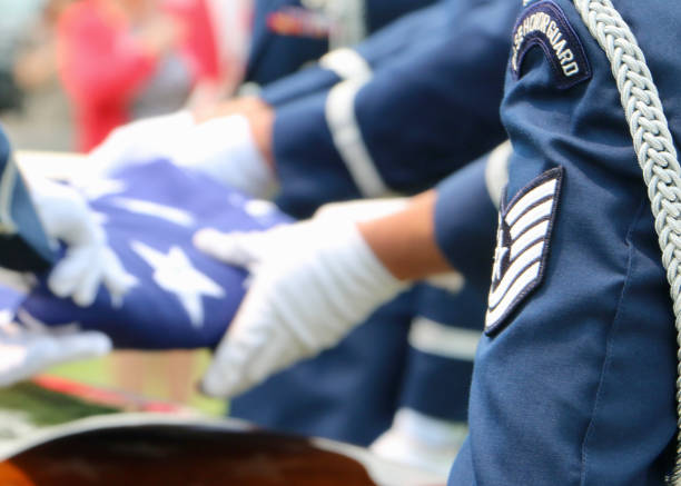 US Air Force Honor Guard with American flag Selective focus, US Air Force Honor Guardsmen folding American flag over casket air force salute stock pictures, royalty-free photos & images