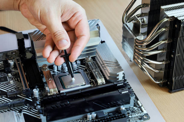 istock Hand squeezes little thermal grease to processor for further compound with cooler 1331977719