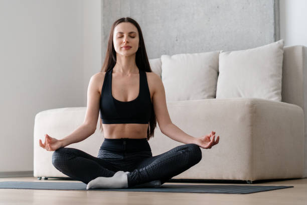 istock Woman sitting in lotus pose and meditating 1331978280