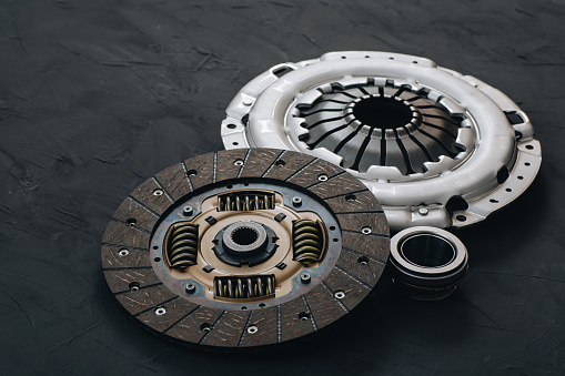 Automotive clutch mechanism, disc, basket and bearing for auto on a black background. Car parts. Close up
