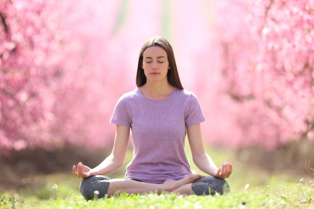 istock Woman practicing yoga in a beautiful pink field 1331983869