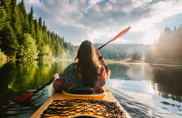 There's an explorer inside everyone of us! Shot of a beautiful young woman kayaking on a lake outdoors canoeing stock pictures, royalty-free photos & images