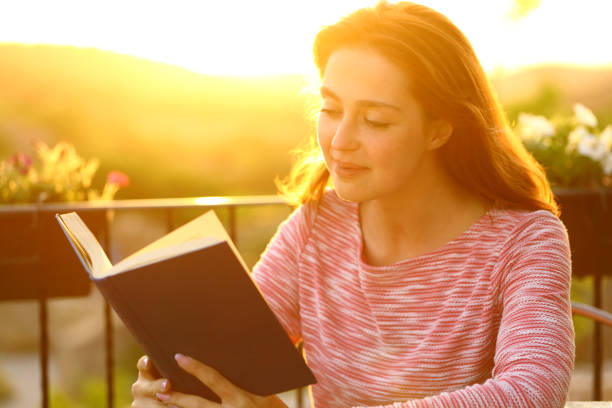 istock Relaxed woman reading a book in a balcony at sunset 1331989588