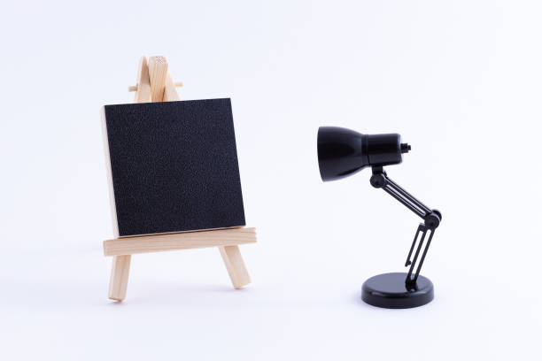 istock Wooden Easel Miniature with Blank Black Square Canvas and Table Lamp 1331990298