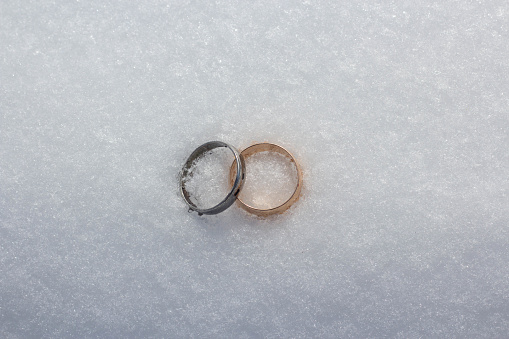 Gold and silver wedding ring on snow background. Islamic wedding concept.