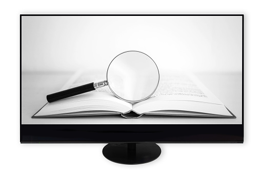 Modern wide screen computer monitor showing open book with large magnifying glass against white background
