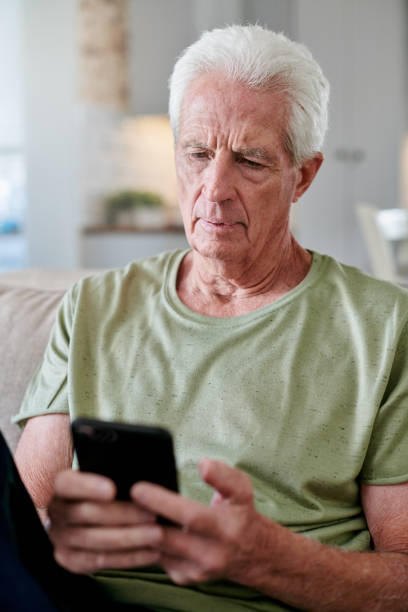istock Shot of a senior man using his cellphone while sitting at home 1331997691