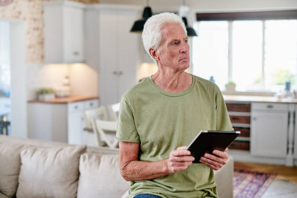 istock Shot of a senior man using a digital tablet while sitting at home 1331997740