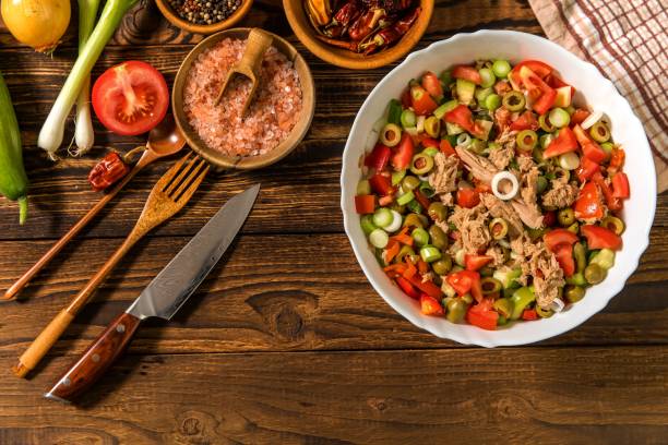 salada de atum saborosa com legumes na mesa de madeira. salada vegetal com atum. preparando uma salada vegetal saudável com peixe. comida dietética para atletas. - tuna steak tuna steak olive oil - fotografias e filmes do acervo