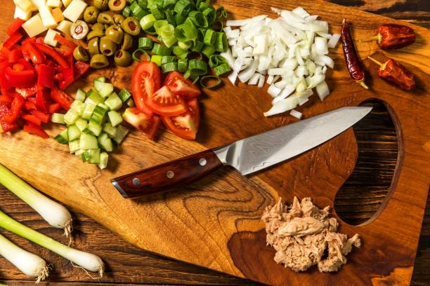 вкусный салат из тунца с овощами на деревянном столе. овощной салат с тунцом. приготовление полезного овощного салата с рыбой. диетическое � - tuna steak tuna steak olive oil стоковые фото и изображения