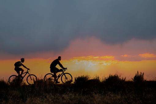 man and woman on bicycles on the background of a very beautiful sunset
