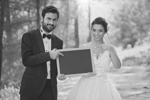 istock Wedding couple holding a blackboard. Save the date. 1332006041