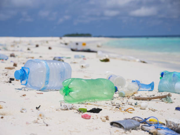 Scenic view of tropical beach littered in garbage Plastic bottles and other garbage on white sand beach indo pacific ocean stock pictures, royalty-free photos & images