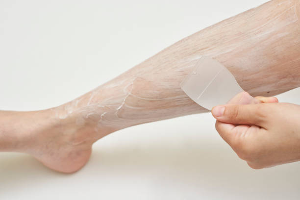 женщина, наносящая слой крема для депиляции на волоски ног - depilatory cream стоковые фото и изображения