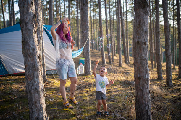 istock Mother and son having fun in nature making soap bubbles 1332008793