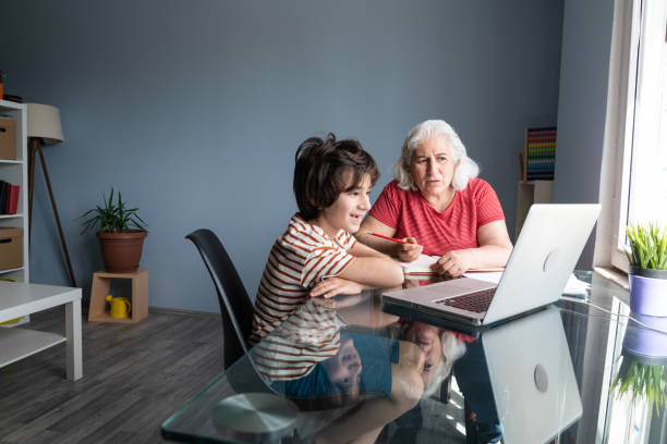 istock Senior Grandmother And Grandson Using Laptop Computer At Home 1332011078