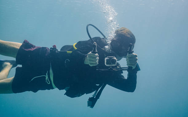 istock Underwater view of scuba diver filming on underwater camera 1332011173