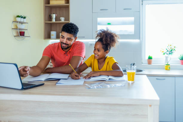 istock Father helping daughter do the homework at the kitchen table 1332014711