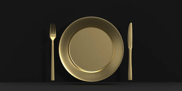 a golden dish set with a fork and knife and a plate on black background - table knife silverware black fork imagens e fotografias de stock