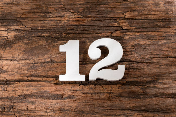 istock Number twelve - White Piece on Rustic Wood Background 1332021725