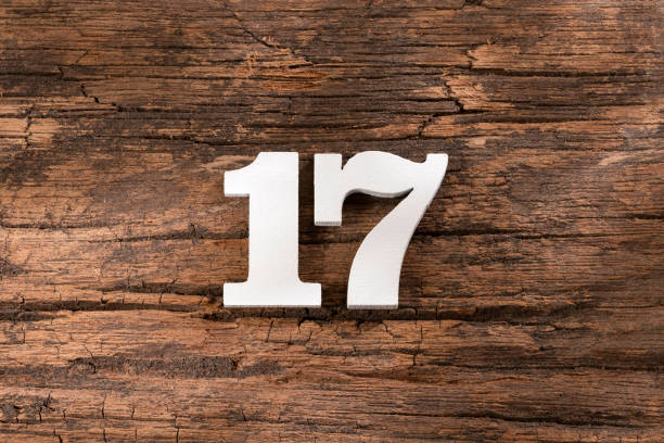 istock Number seventeen - White Piece on Rustic Wood Background 1332021727