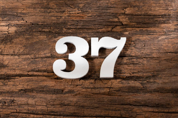 istock Number thirty seven 37 - White Piece on Rustic Wood Background 1332022331