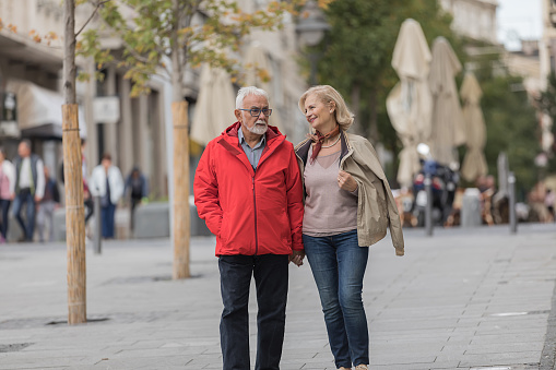 Portrait of Cheerful Senior Couple who is Exploring the City While Walking and Having a Nice Conversation.