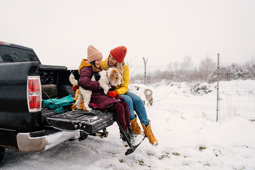 Photo of mother, daughter and their family dog on the road trip